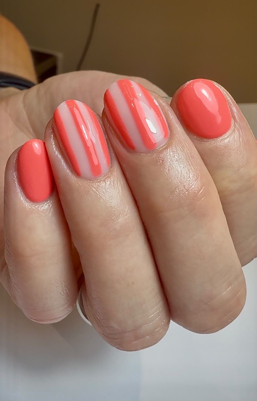 Bright coral manicure with soft striped nail art